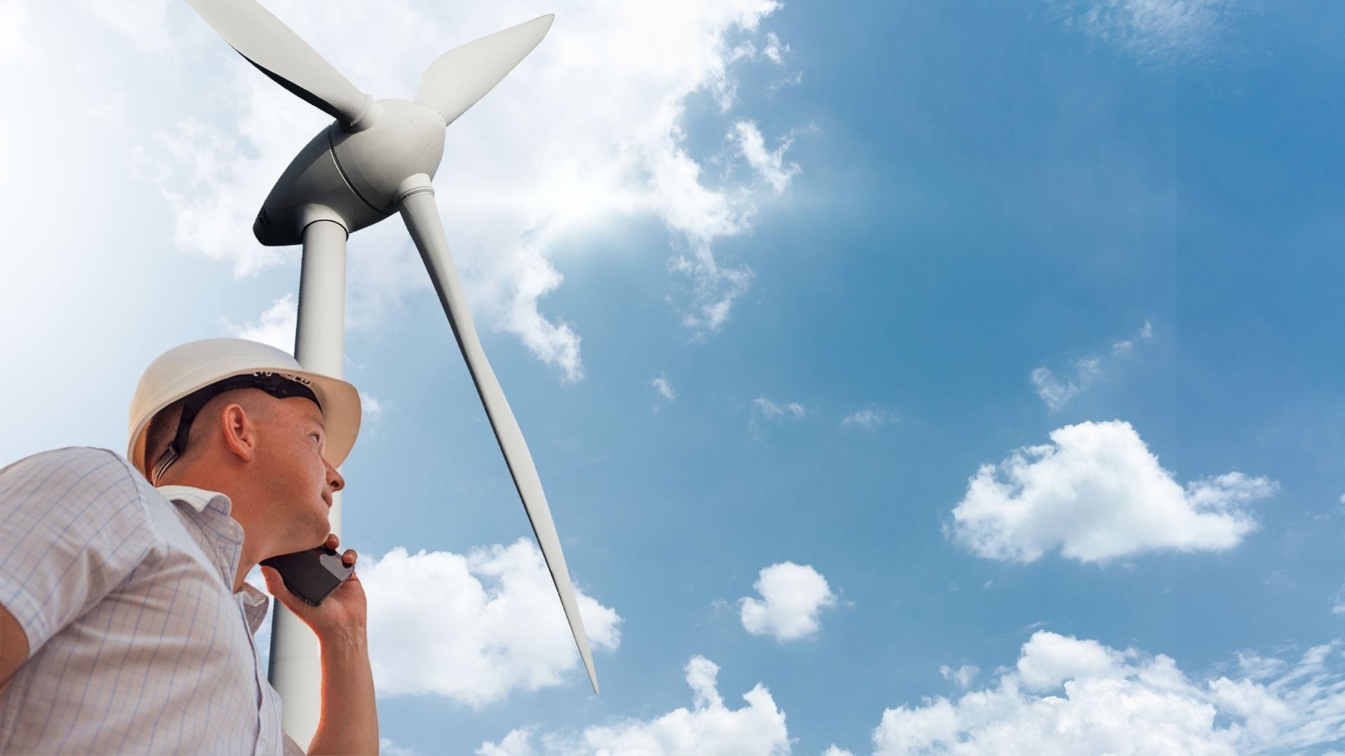 Mann telefoniert mit NBB vor Windenergieanlage